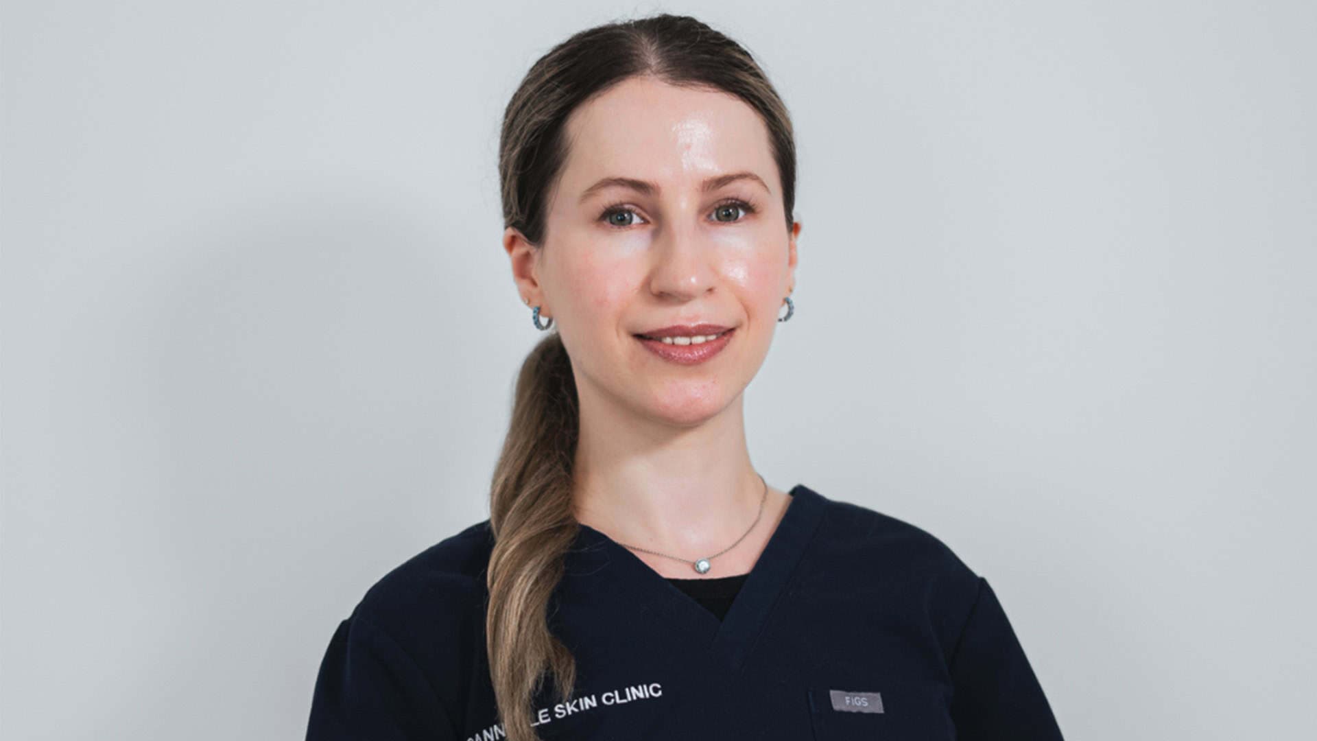 Professional skin care specialist smiling at Cannelle Skin Clinic.