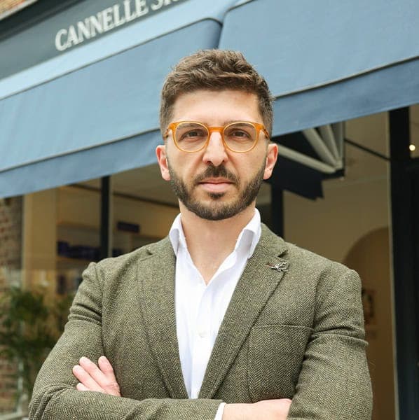 Man standing outside Cannelle Skin Clinic with arms crossed, professional appearance.
