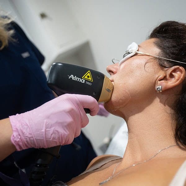 Woman receiving skin treatment with laser device at Cannelle Skin Clinic.