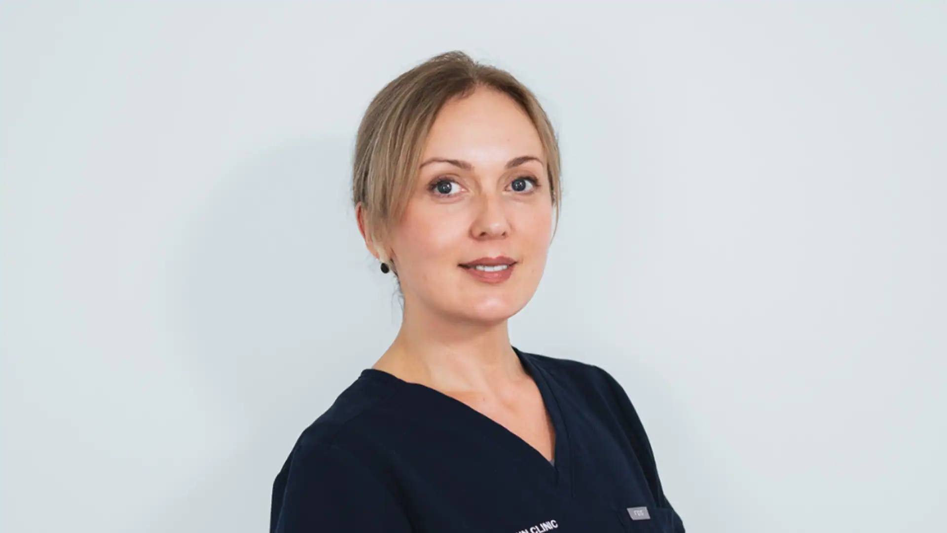A woman skincare specialist in professional uniform at Cannelle Skin Clinic.