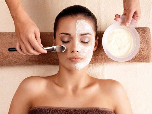 Woman receiving a facial treatment with cream application at Cannelle Skin Clinic.