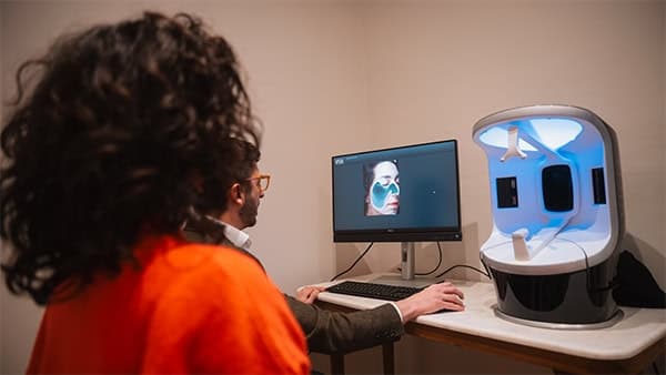 Woman undergoing skin analysis with advanced facial scanning technology.
