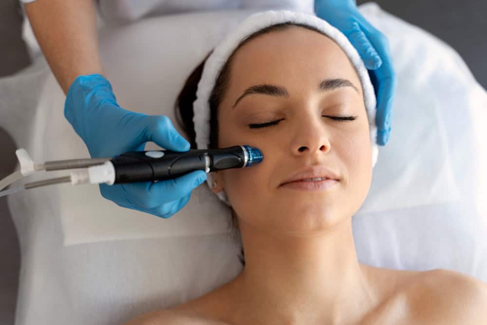 Woman receiving facial treatment with a skincare device at Cannelle Skin Clinic.