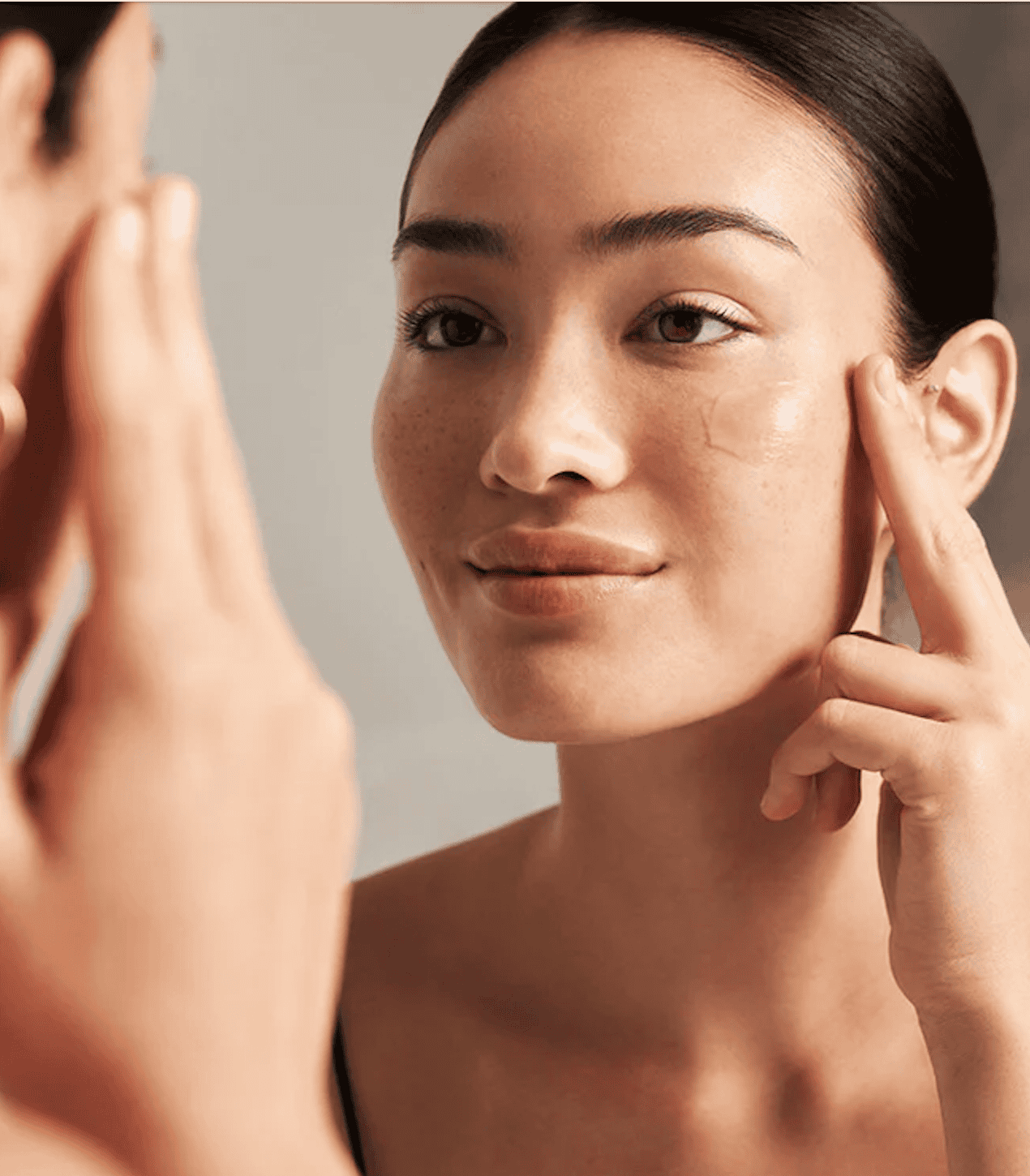 Woman receiving a skin consultation, close-up of her face and dermatologist's hand.