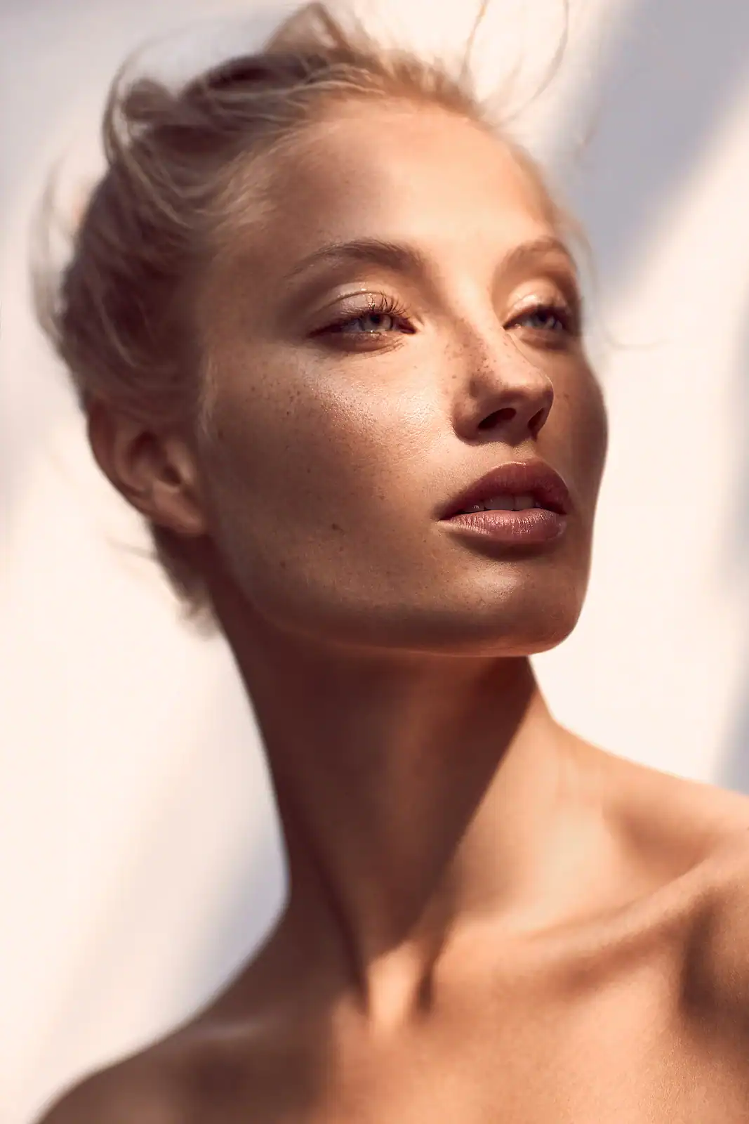 Close-up of a young woman with clear, glowing skin and natural makeup, showcasing skincare and beaut.
