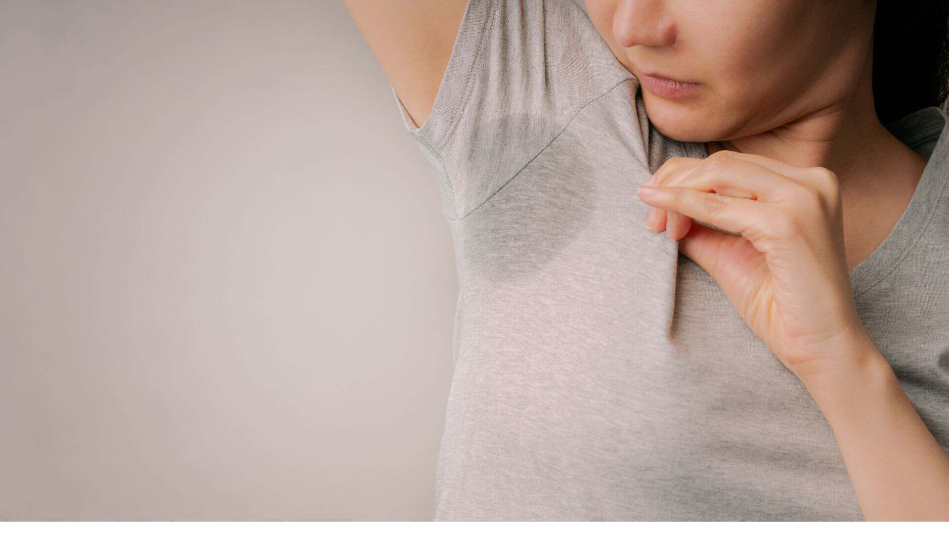 Woman examining underarm skin, skincare consultation at Cannelle Skin Clinic.