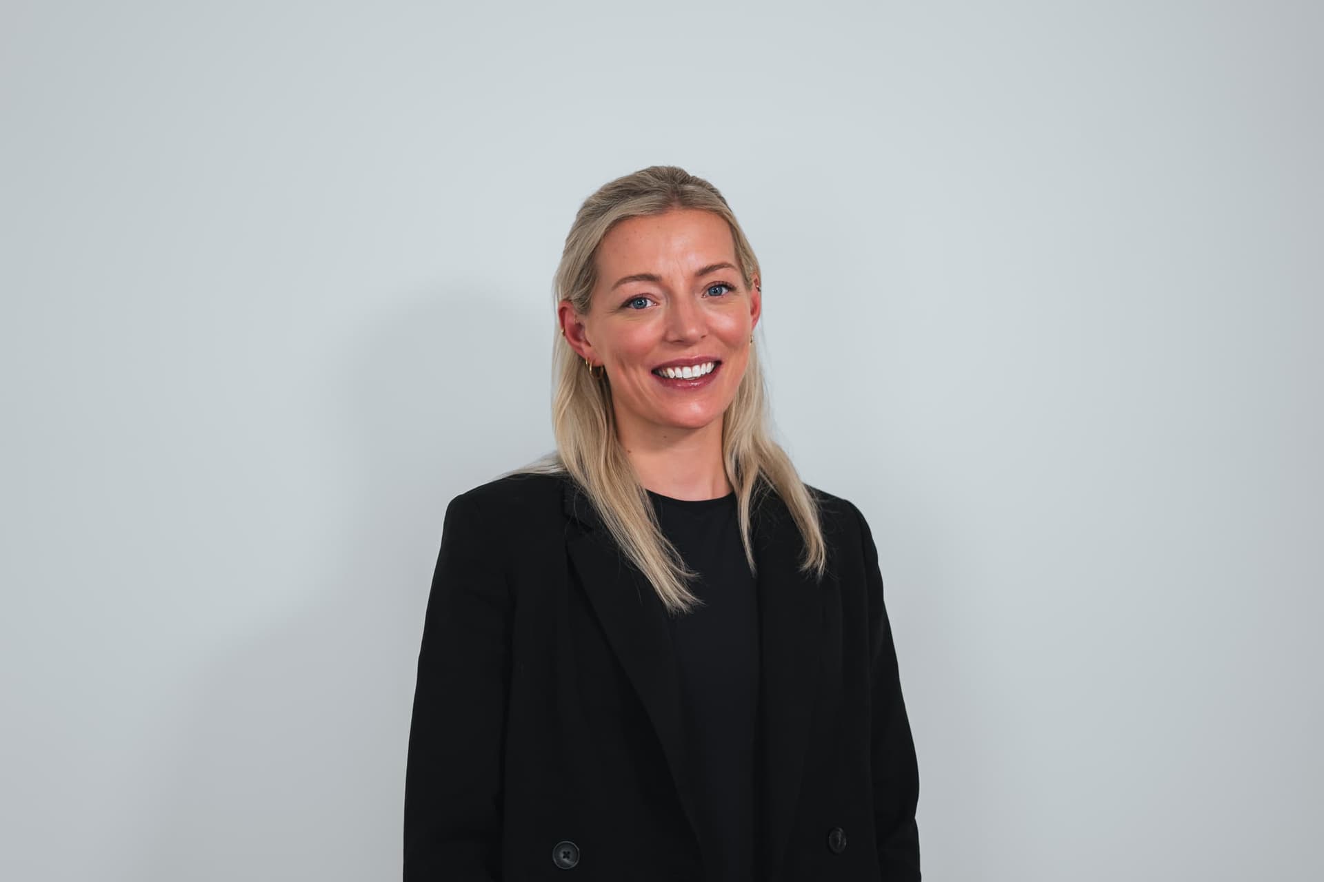 Healthy woman smiling in professional attire at Cannelle Skin Clinic.