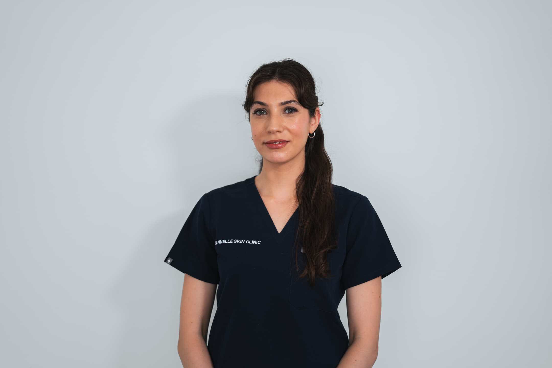 Professional skincare specialist in navy uniform at Cannelle Skin Clinic.