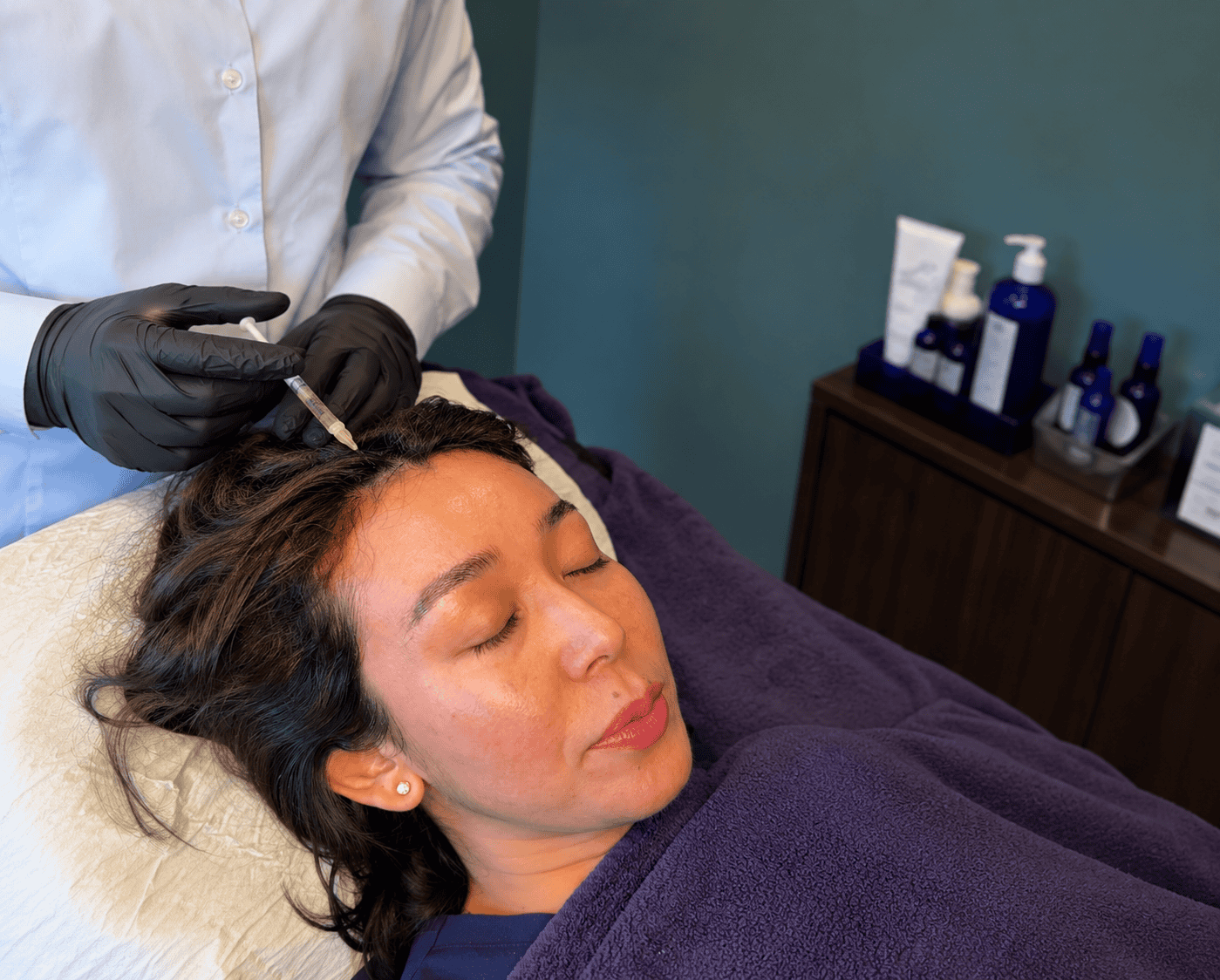 Woman receiving skin treatment at Cannelle Skin Clinic, professional skincare service in progress.