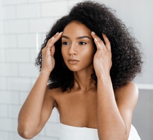 woman looking in the mirror at her skin